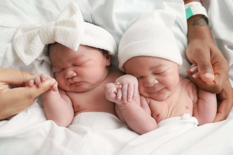 Little sister Souli Morris snuggles up next to big brother Seven Morris. The twins were born three minutes apart, but in different years. 