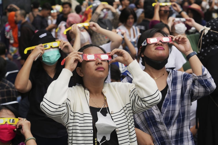 People wear protective glasses to watch a solar eclipse in Jakarta, Indonesia, on April 20.