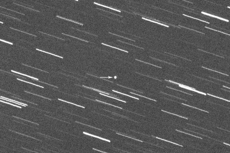 A single 180-second exposure  black and white image with an arrow pointing at the asteroid.
