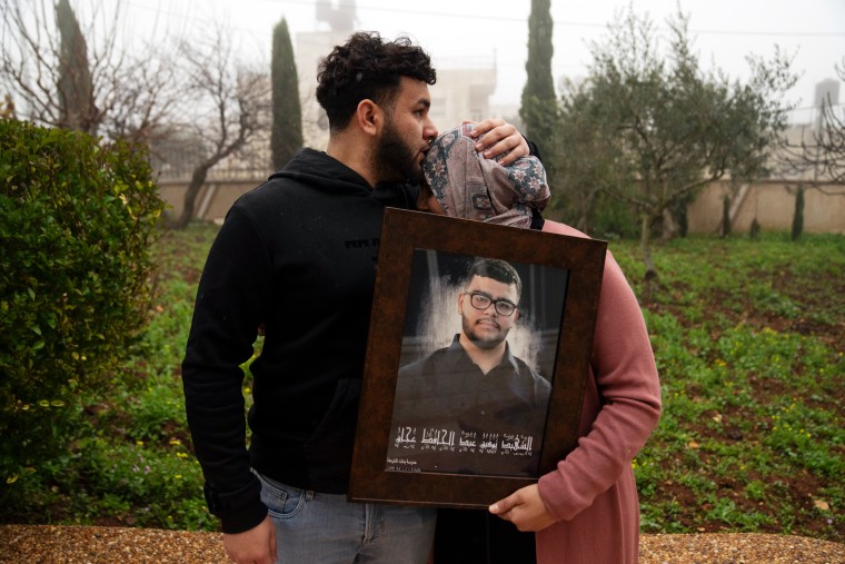 Amir Abdel Jabbar comforts his mother, Mona, in their home village of Al-Mazra'a ash-Sharqiya in the West Bank on January 23. 