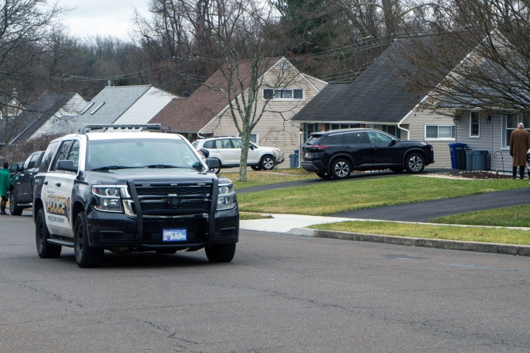 A police car drives through the neighborhood. 