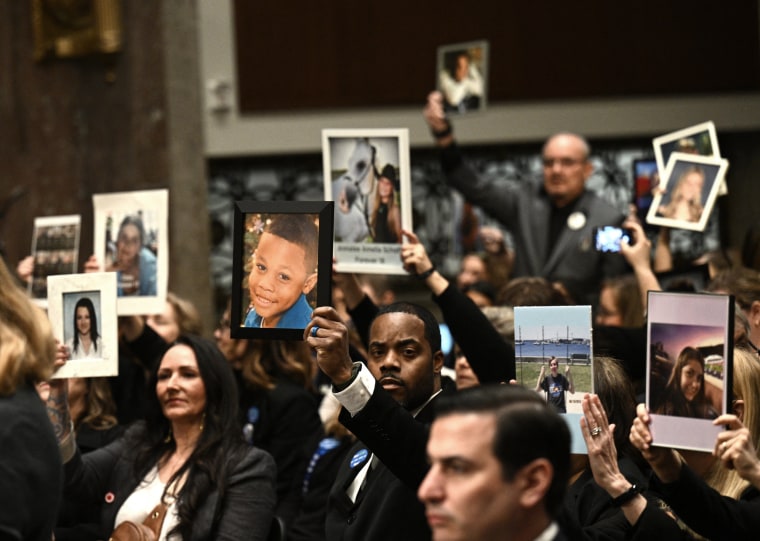 Relatives of victims hold their portraits