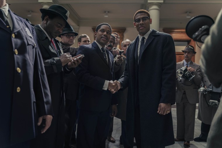 Martin Luther King Jr., played by Kelvin Harrison Jr., and Malcolm X, played by Aaron Pierre, are surrounded by reporters in the Senate as seen in GENIUS: MLK/X.