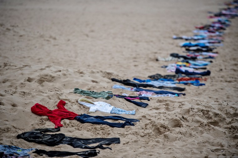 Activists lay out a 3-mile line of second-hand children's clothes along Bournemouth beach in England to illustrate the scale of child deaths in Gaza and Israel, with each set of clothing representing a lost child, on Feb .3 5, 2024.