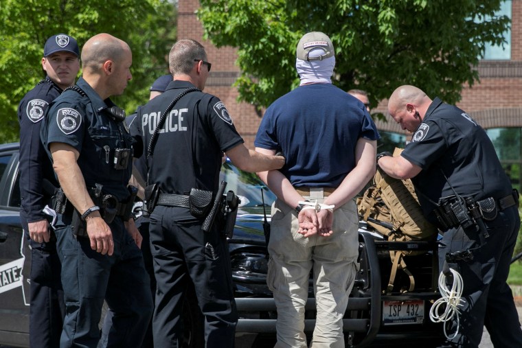 A member of the white nationalist group Patriot Front is searched by police after being arrested outside of Mceuen Park in Coeur d' Alene, Idaho