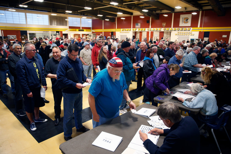 crowds of people line up to get a ballot at a Republican caucus site 