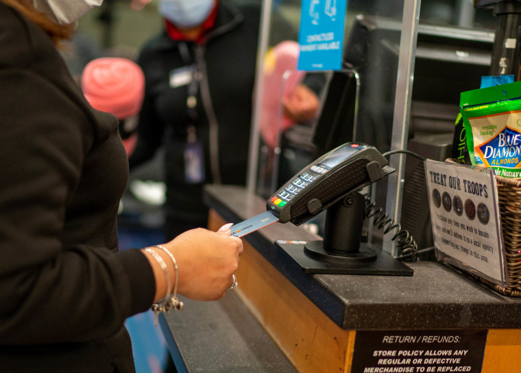 An air traveler uses a credit card to pay for items on January 28, 2022 at a retail shop in John F. Kennedy International Airport in New York City. 
