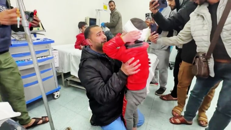 Palestinian doctor Dr.  Rami Abu Libdeh holds his 9-year-old son Muhammad in a hospital in Rafah, Gaza, on February 8, 2024.