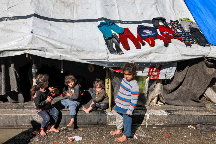 Children gather outside a tent sheltering displaced Palestinians in Rafah in the southern Gaza Strip on February 8, 2024.