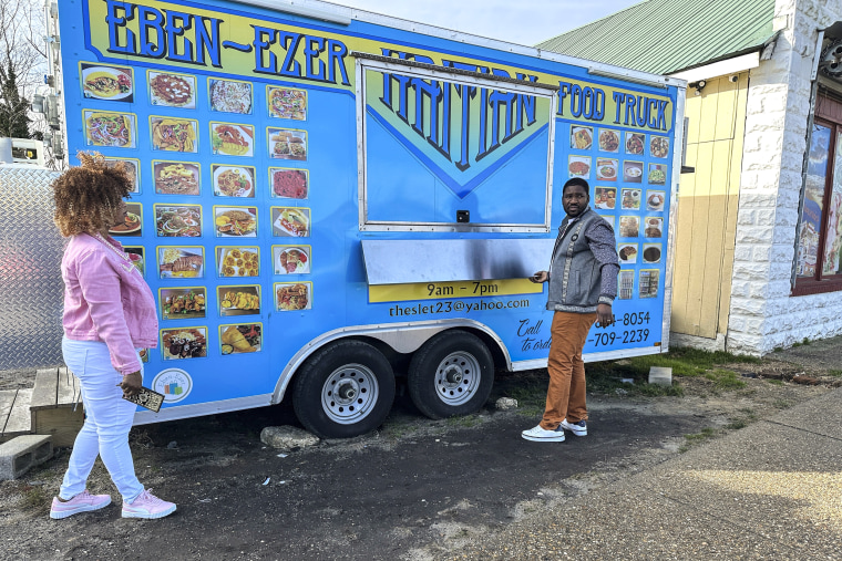 Image: Clemene Bastien and Theslet Benoir stand outside of their Eben-Ezer Haitian food truck