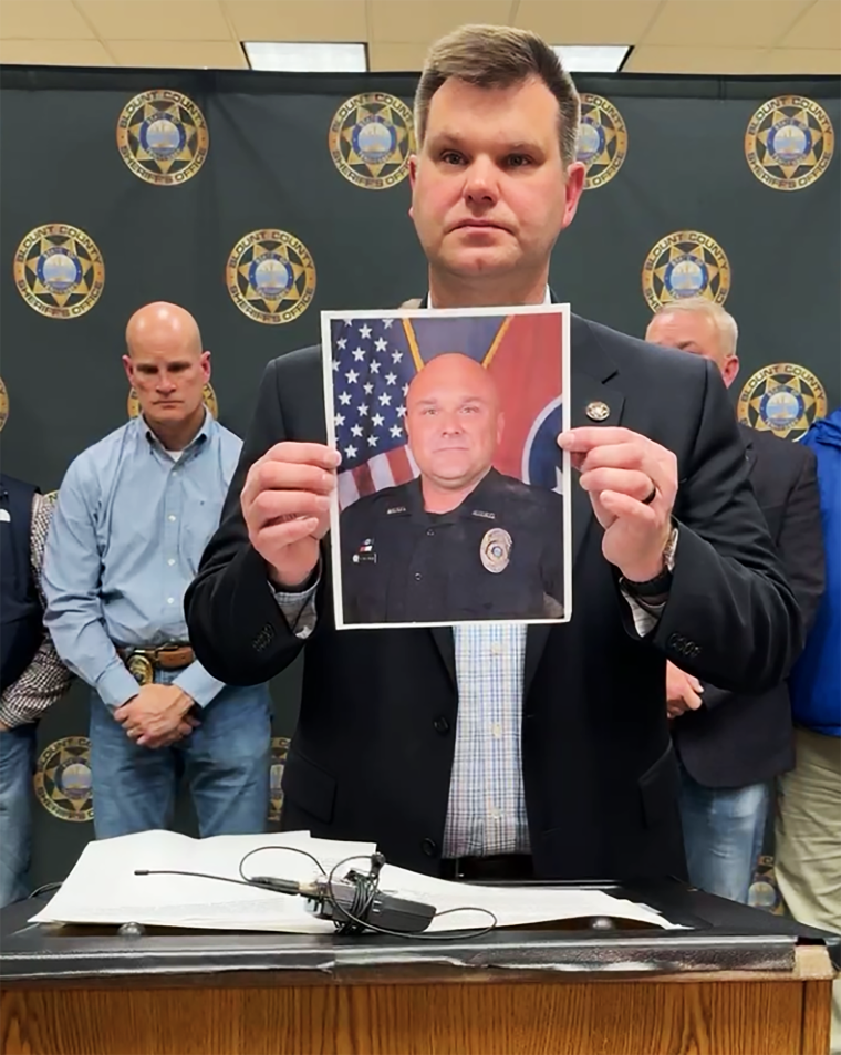 An image of Blount County officer Greg McCowan is raised during a press conference after his death was confirmed by authorities early Friday morning.