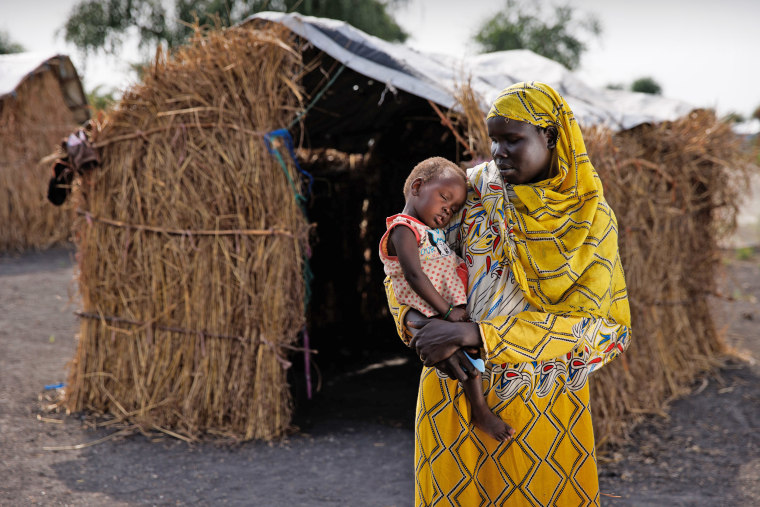 Nyekuon Gai holds her daughter outside her shelter in an Internally Displaced Persons (IDP) camp on Nov. 29, 2023 in Rotriak, South Sudan. 