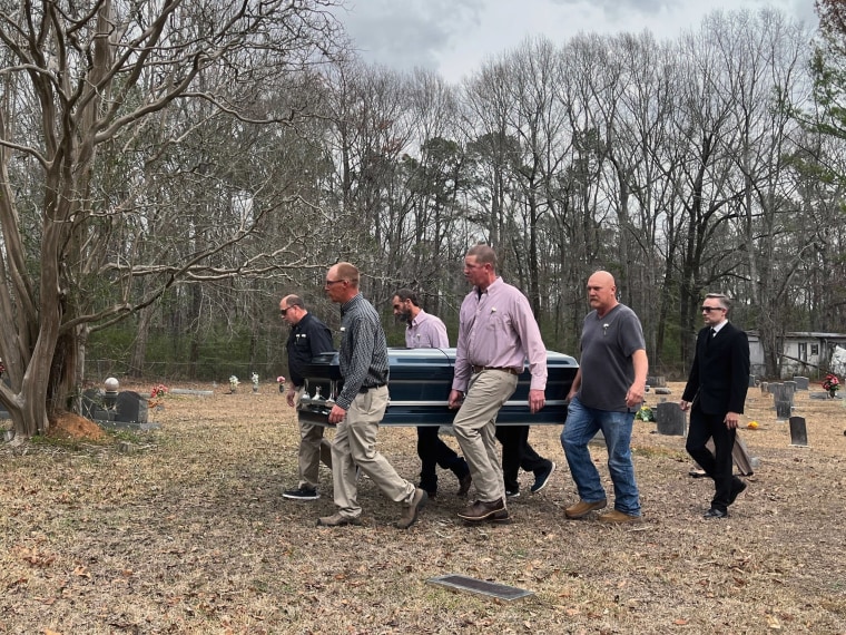 Pallbearers carry Jonathan's casket to the funeral service next to his grave.