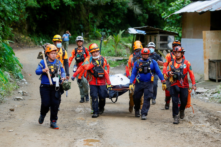 Rescuers carry a body bag as search and rescue operations continue in the landslide-hit village of Masara, Maco, Davao de Oro, Philippines, February 8, 2024. 