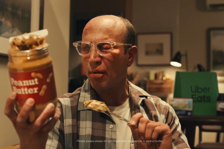A scene from Uber Eats' 2024 Super Bowl NFL football spot shows a man holding a bowl of peanut butter.