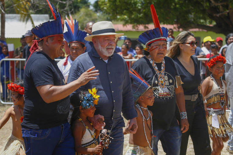 Brazil's President Luiz Inacio Lula da Silva, second left, and first lady Rosangela Silva, second from right, are received by an Indigenous party including Davi Kopenawa, a Yanomami leader and shaman, third from right, at the Caracarana Lake Regional Center in Normandia, on the Raposa Serra do Sol Indigenous reserve in Roraima state, Brazil, on March 13, 2023.