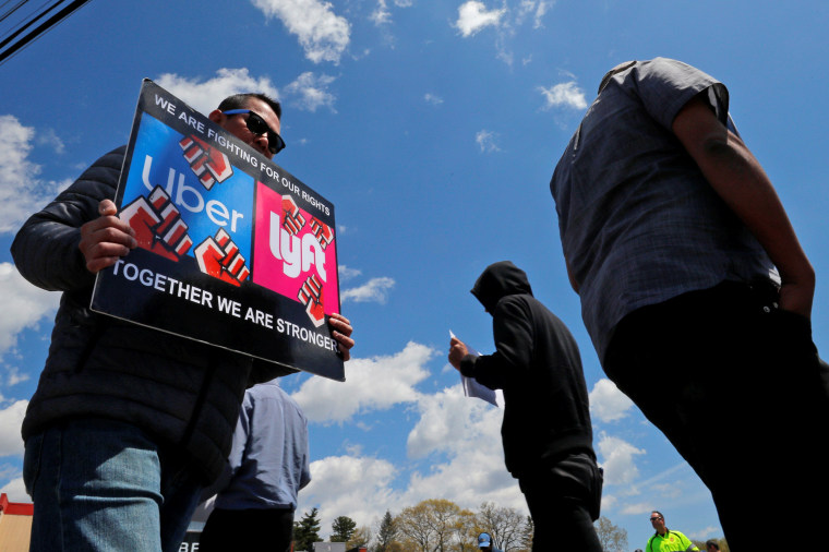 Uber and Lyft drivers protest during a day-long strike outside Uber’s office in Saugus