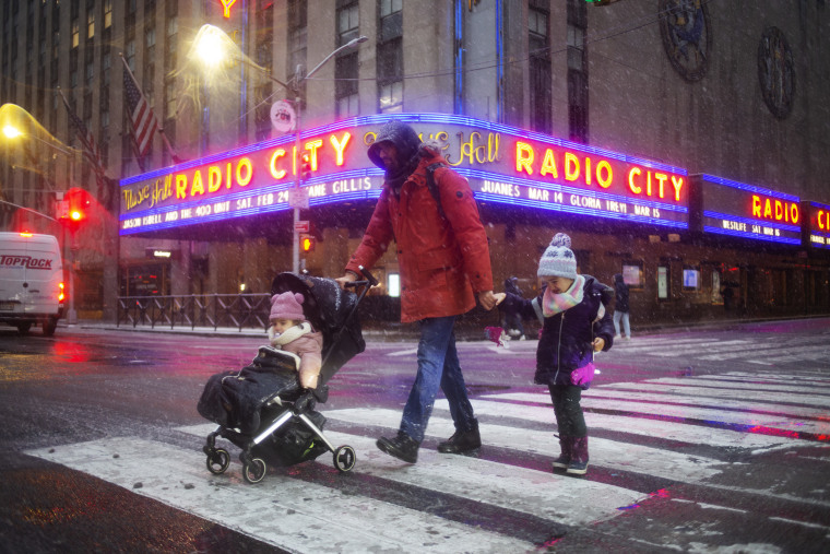 Snow falls in Midtown Manhattan in front of Radio City Music Hall on Feb. 13, 2024.