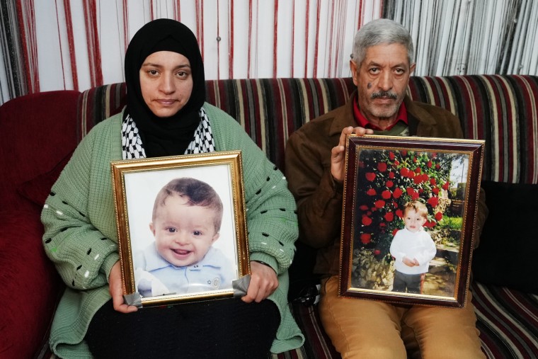 Mohammed Khdour's parents holding photos of Mohammed.