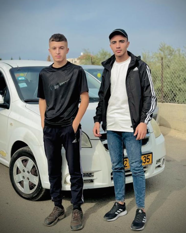 Mohammed Khdour, left, with his cousin Malek Mansour stand in front of a car.
