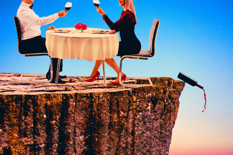 تصویر کی مثال: ایک جوڑے پہاڑ کے کنارے رات کا کھانا کھا رہے ہیں، جب شراب کی بوتل کنارے پر گر رہی ہے