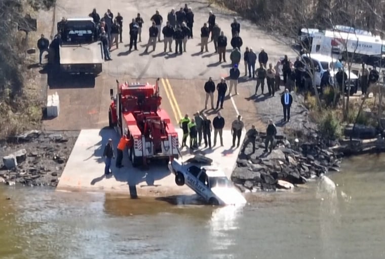 The patrol car belonging to a missing Tennessee deputy was pulled from a lake Feb. 15, 2024.. The body of a woman under arrest was found in the back seat, but the deputy has not been located. 