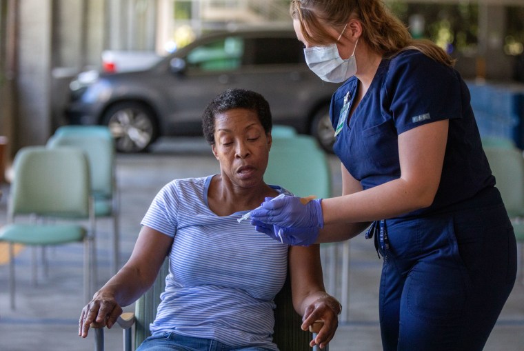 Denise Fractious, 68, left, of Pasadena, receives her COVID vaccine from Tracy Gage, LVN, right, during a flu and COVID-19 vaccination clinic at Kaiser Permanente Pasadena on Oct. 12, 2023, in Pasadena, CA.