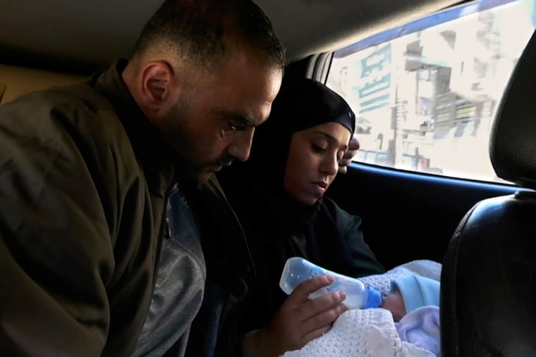 Anas Stateh is fed by his mother in the back of a vehicle. 