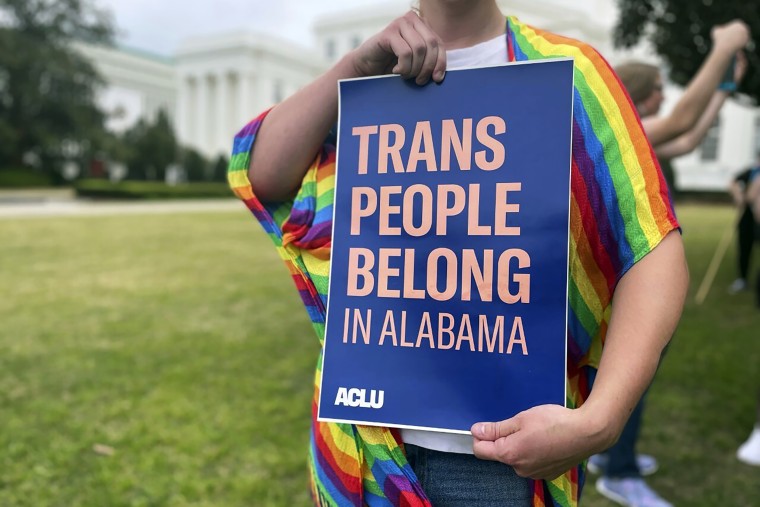 A person holds up a sign reading, "Trans People Belong in Alabama," during a rally outside the Alabama Statehouse in Montgomery, Ala., on International Transgender Day of Visibility, March 31, 2023. 