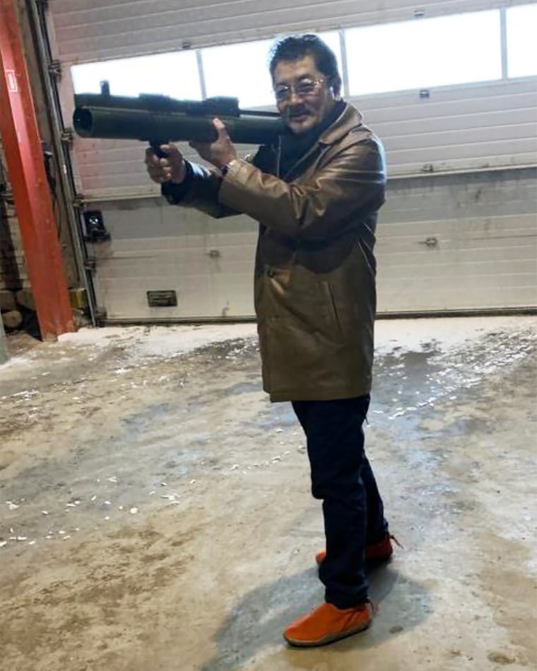 Takeshi Ebisawa poses with a rocket launcher during a meeting with an informant at a warehouse in Copenhagen