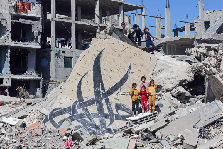 Children stand amid the rubble of a building destroyed in Israeli bombardment in Rafah, Gaza, on Thursday.