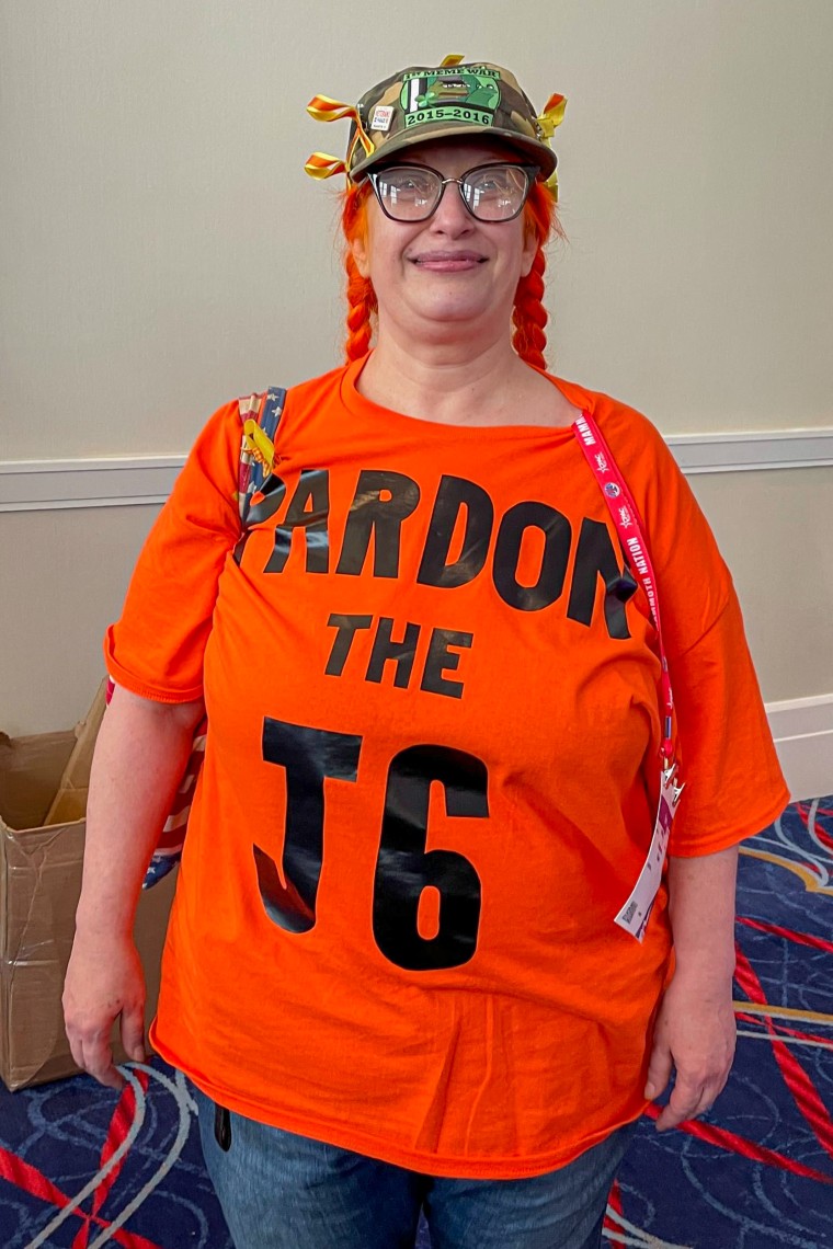 Suzzanne Monk with an orange shirt that reads "Pardon the J6,"