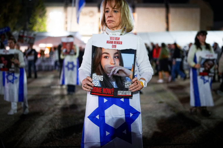 A woman holds a poster of a missing Israeli hostage