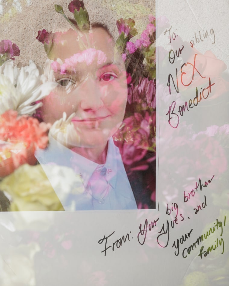 A photo of Nex Benedict with a note is left alongside flowers