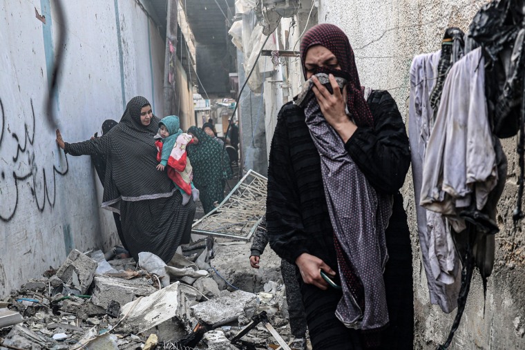 People find their way through a rubble-covered alley, following overnight Israeli bombardment in Rafah, Gaza, on Sunday.