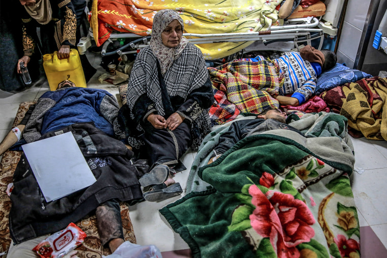 Image:  A woman sits among Palestinians at Al-Shifa hospital in Gaza City 