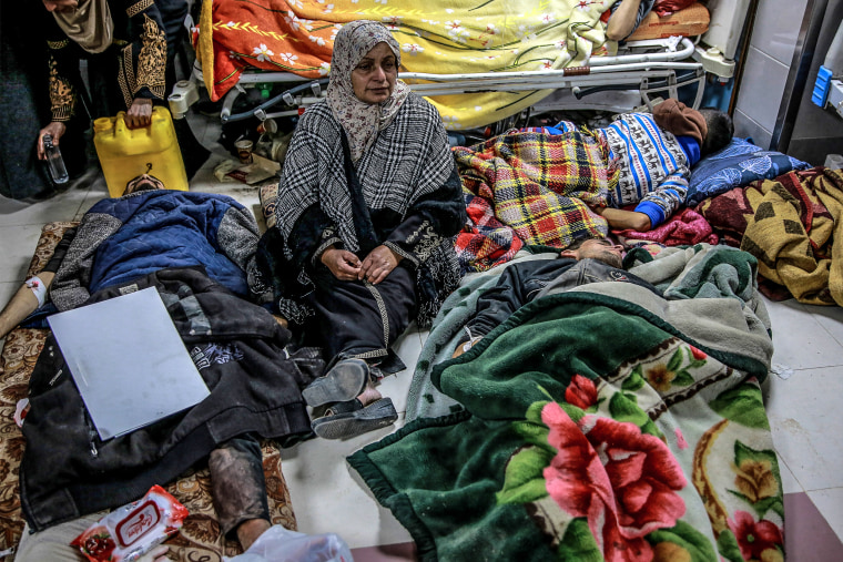 Image: A woman sits among Palestinians at Al-Shifa hospital in Gaza City 