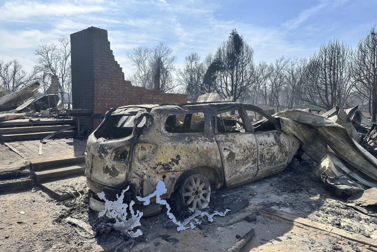 A burned car rests near the charred remains of a home outside of Canadian, Texas