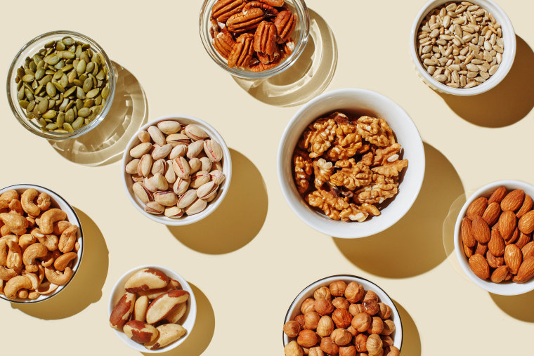 Pattern of various nuts on a background. Includes: pecan, brazil nut, walnut, almonds, hazelnuts, pistachios, cashews.