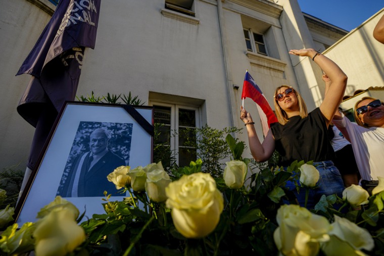 Simpatizantes cantan el himno nacional y gritan "larga vida a Piñera", junto al retrato del fallecido expresidente chileno Sebastián Piñera en Santiago de Chile, el 6 de febrero de 2024.
