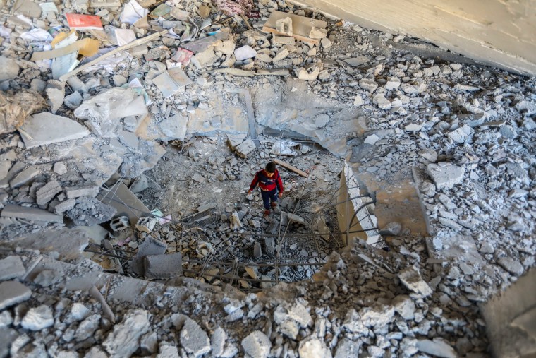 A young person inspects damage to a building following Israeli airstrikes, on Feb. 3 in Rafah, Gaza.
