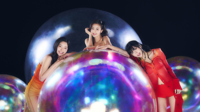 Bright photo shoot with TWICE, Dahyun, Jihyo, and Chaeyoung posing with giant and small shaped balloons on a dark background