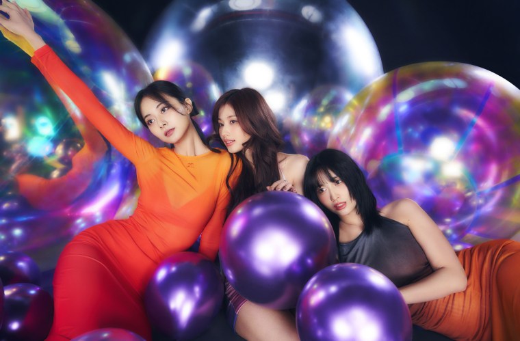 Bright photo shoot with TWICE, Tzuyu, Sana, and Momo posing with giant and small shaped balloons on a dark background