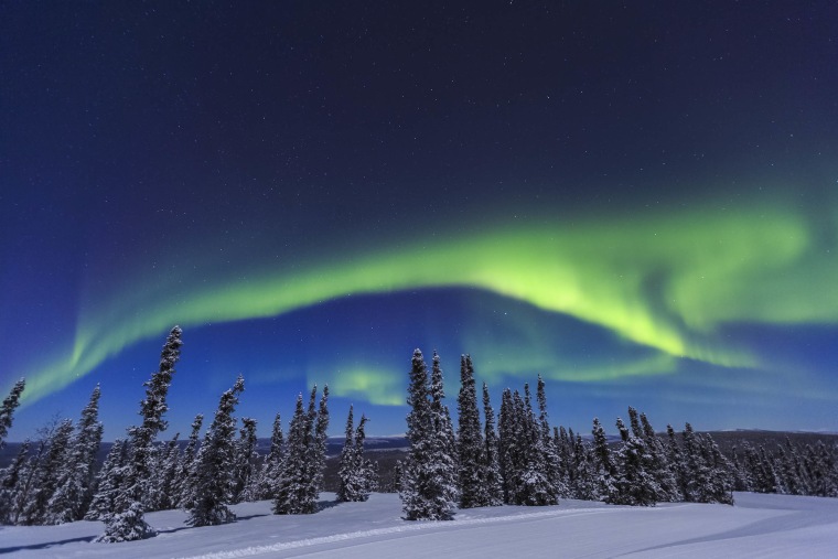 Aurora borealis, Northern Lights above tent lit up with lantern, near Chena Resort, near Fairbanks, Alaska