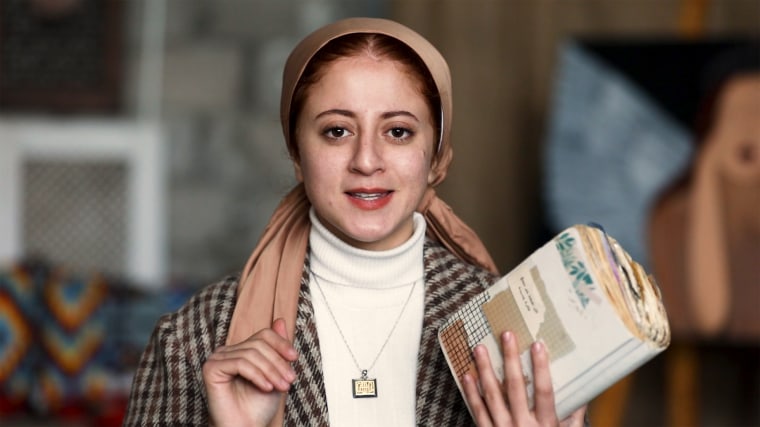 Salma Shurrab, 22, in Cairo, holds her "trauma journal," which she kept amid her 60 days of war in Gaza.