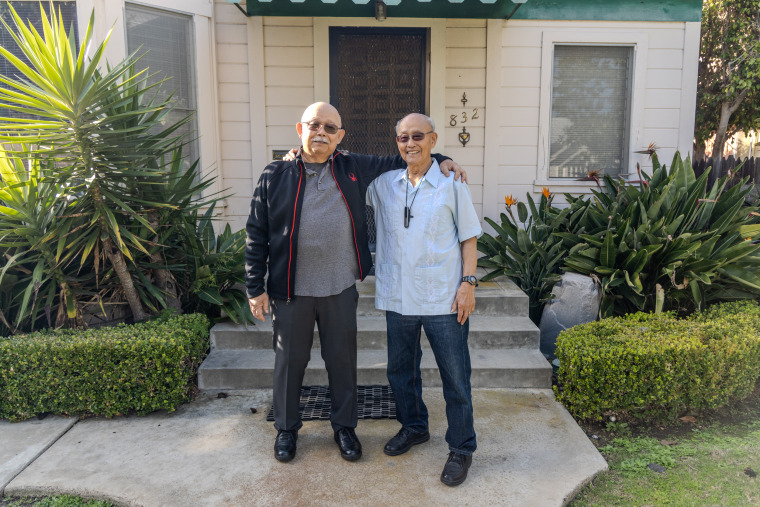 Lloyd Dong Jr., left, and his brother Ron stand outside of their childhood home on C Street in Coronado, Calif. 