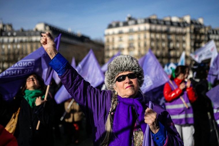 Image: Women hold flags of the "Fondation des Femmes" women's rights group and clench their fists as they gather at the Place du Trocadero in Paris
