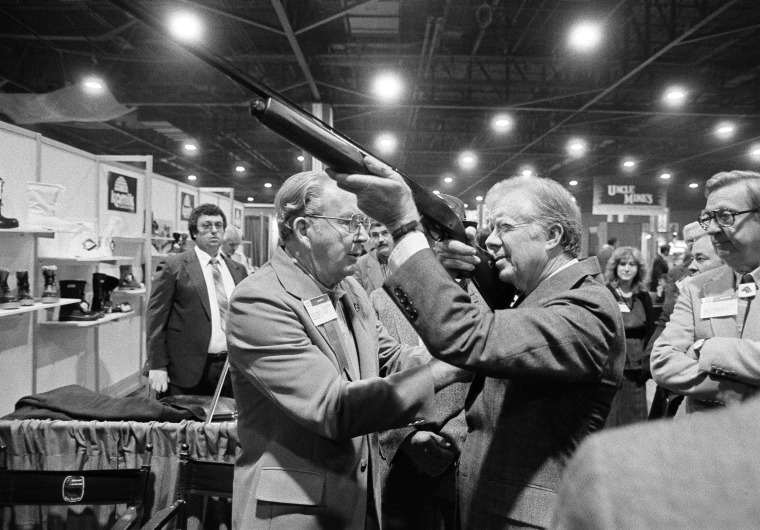 Former President Jimmy Carter holds a shotgun at the NSSF's trade show in Atlanta in 1984.