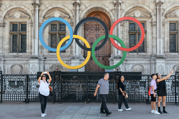 Visitors take photos the Olympic rings. 