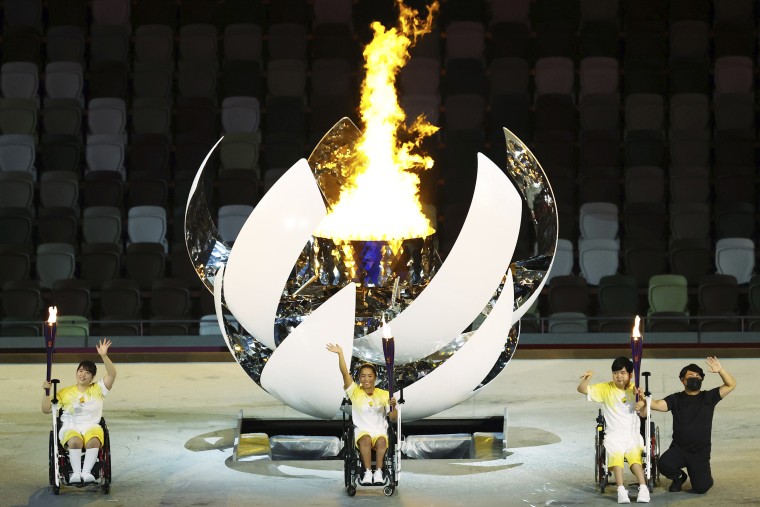 Torch flame bearers ignite the Paralympic cauldron at the opening ceremony of the Paralympic Games in Tokyo on Aug. 24, 2021.